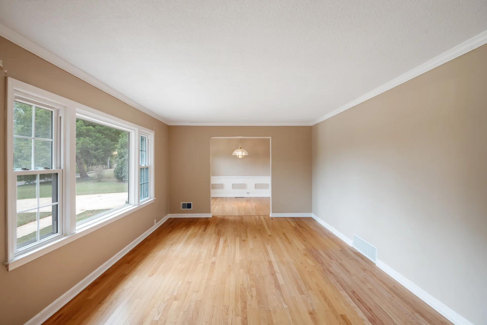 View from the living room into the dining area with hardwood floors and white trim