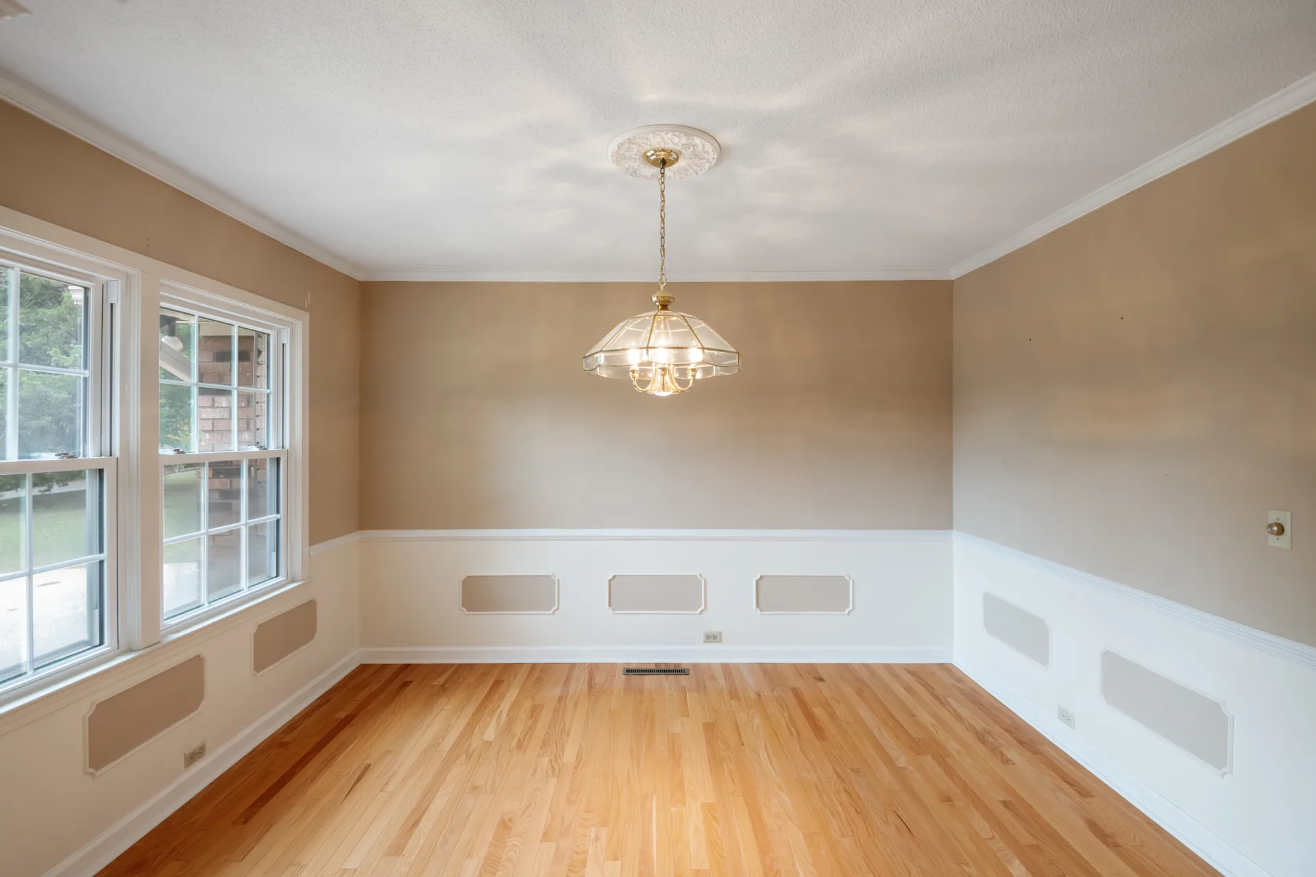 Dining room with white wainscoting and glass-paned windows