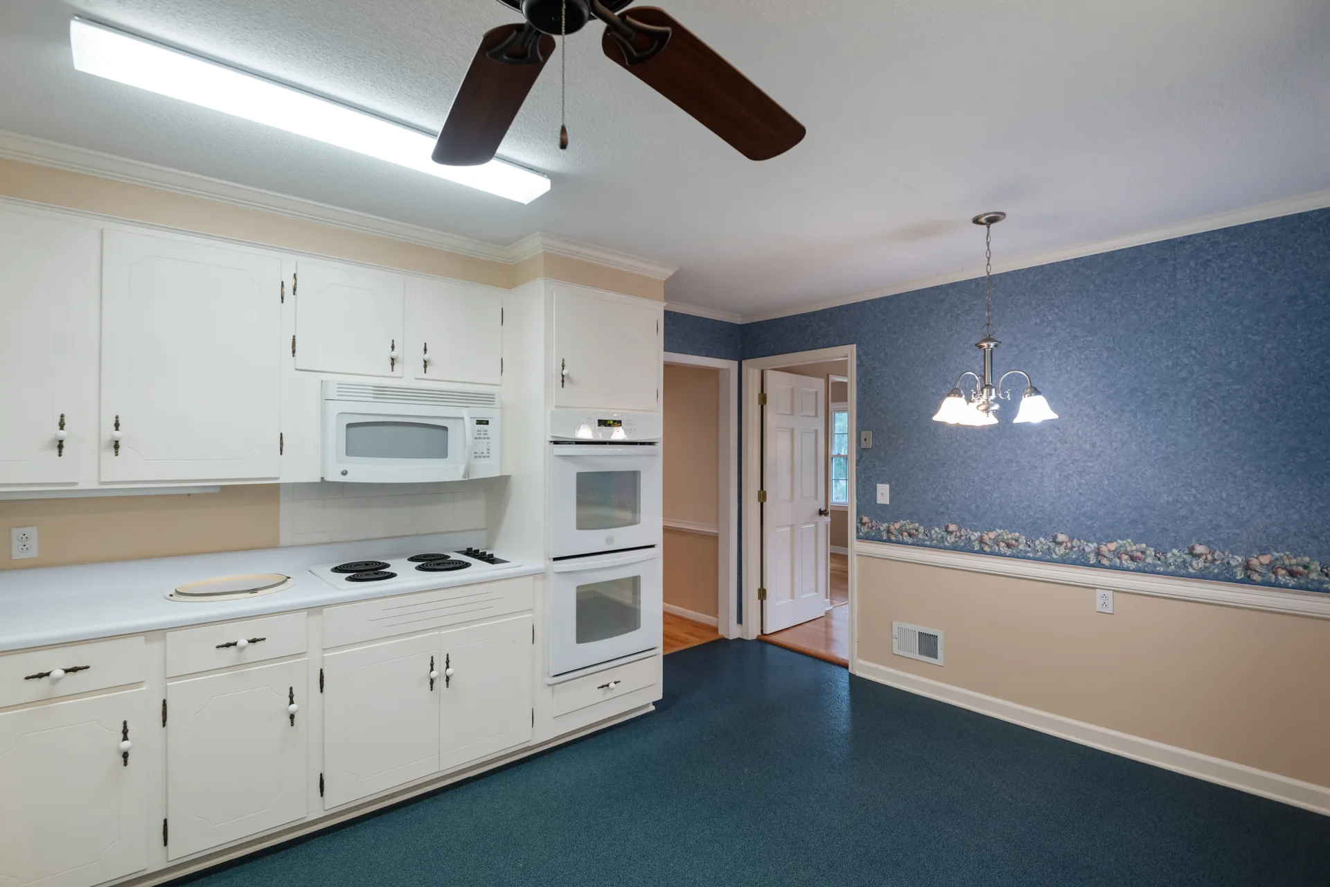 Eat-in kitchen with white cabinetry and an attached dining area