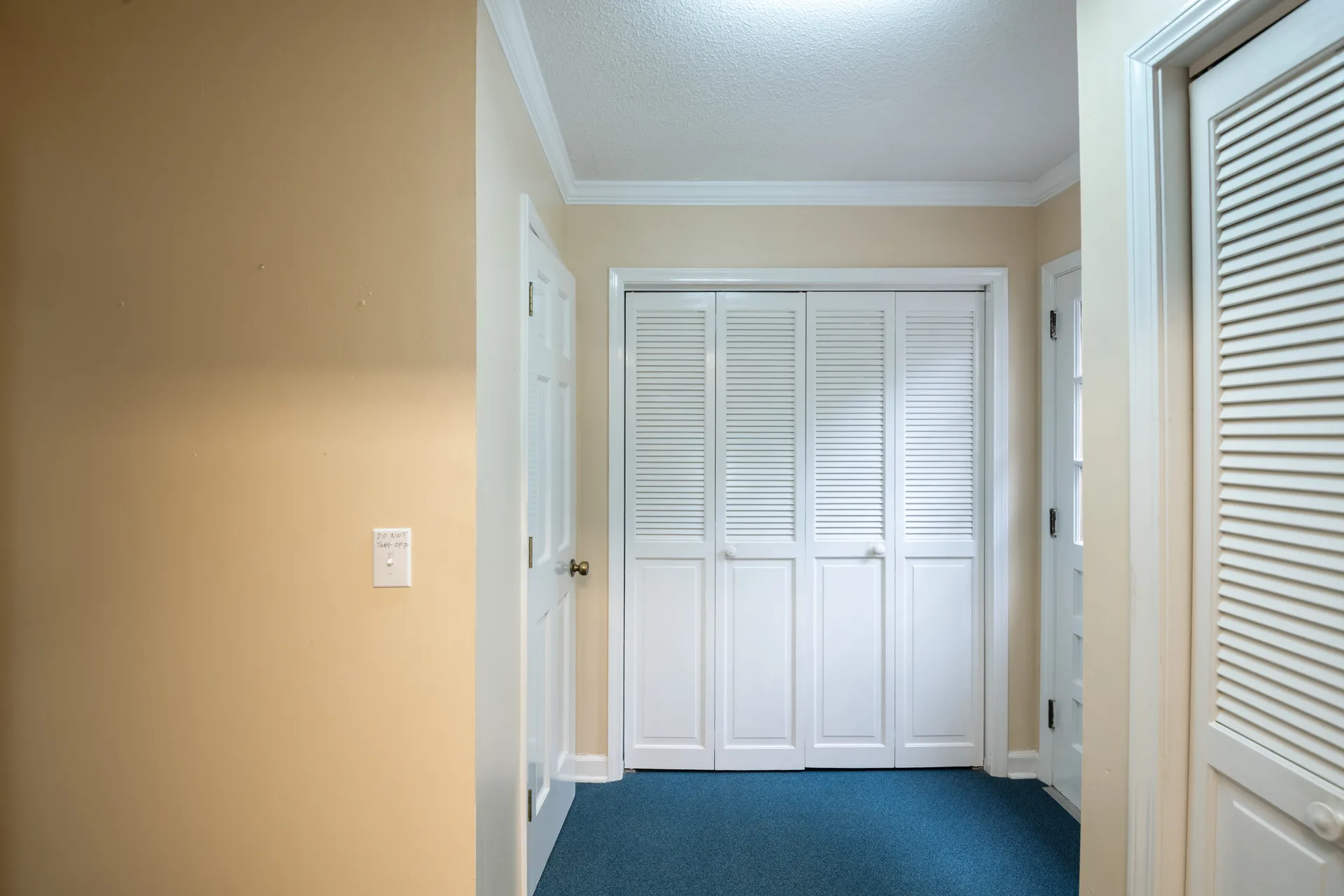 Hallway with white-painted louvered closet doors