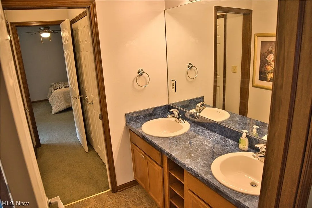Bathroom with a dual vanity and honey oak cabinets