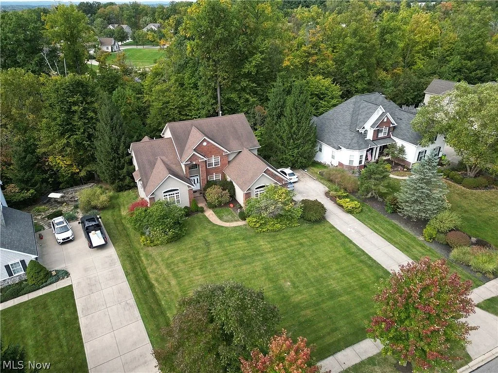 Aerial view of the Colonial home, driveway, and surrounding neighborhood