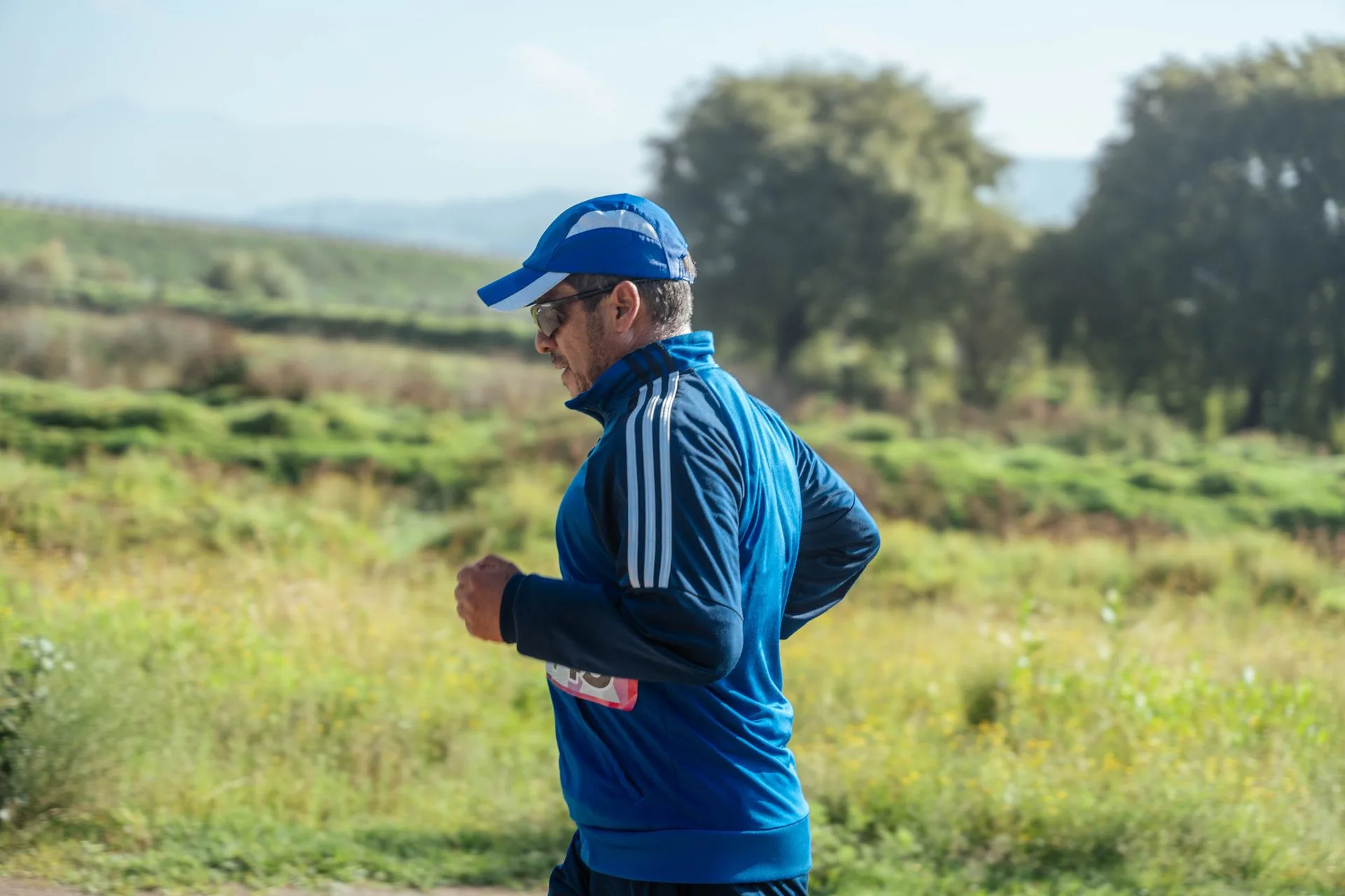 A man jogging outdoors on a park trail, staying active with regular exercise