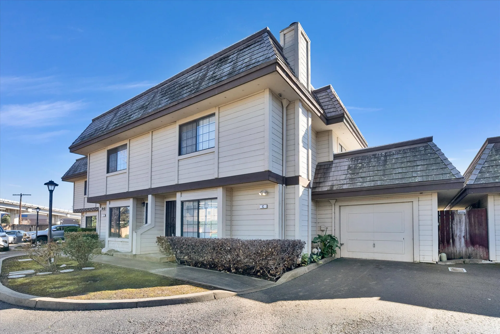 Front exterior of 15205 Hesperian Blvd, Unit C, San Leandro, CA 94578, a two-story townhouse-style condominium with horizontal siding and a mansard-style roof