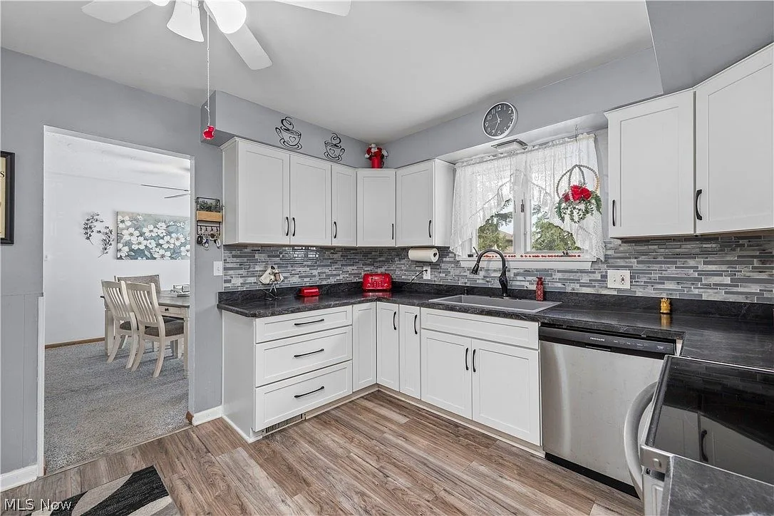 Wide view of the updated white kitchen with wood-look plank flooring