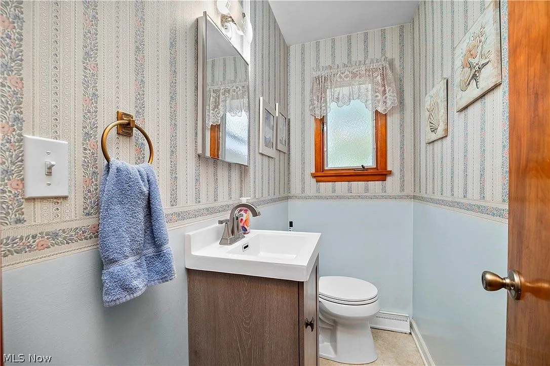 Small half bath with a pedestal vanity and window