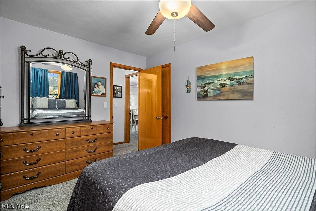 Primary bedroom with grey walls, light carpet, and a queen bed