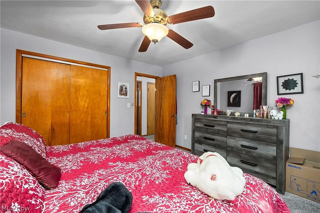 Primary bedroom with wood-grain closet doors and carpeted floors