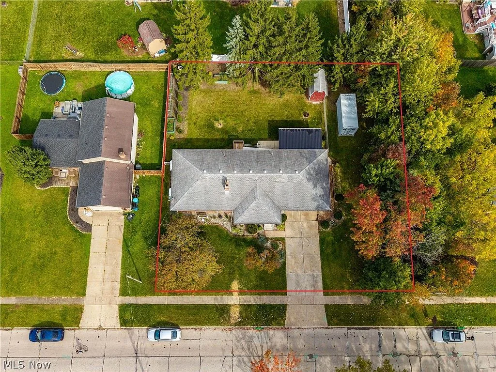 Aerial view of the fenced lot, driveway, and storage sheds at 1426 W 40th St