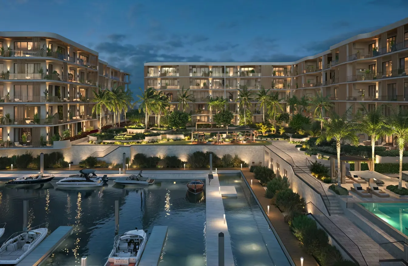 Vista al atardecer de The Halcyon Residences and Marina en Napoles, Florida, con una marina privada, botes amarrados y una piscina iluminada