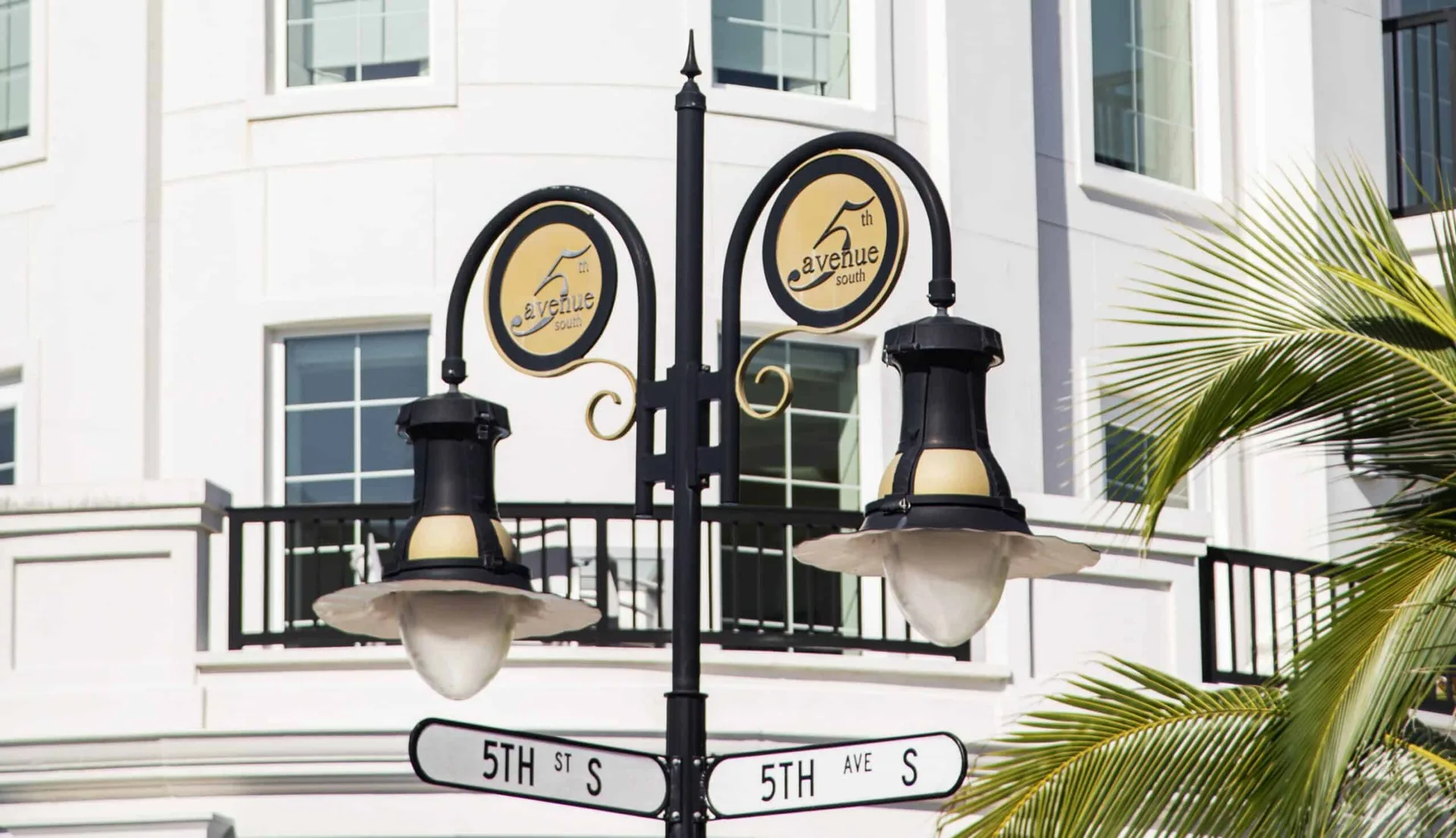 Farol de Fifth Avenue South en Napoles, Florida, un poste negro de dos brazos con senalizacion circular de calle