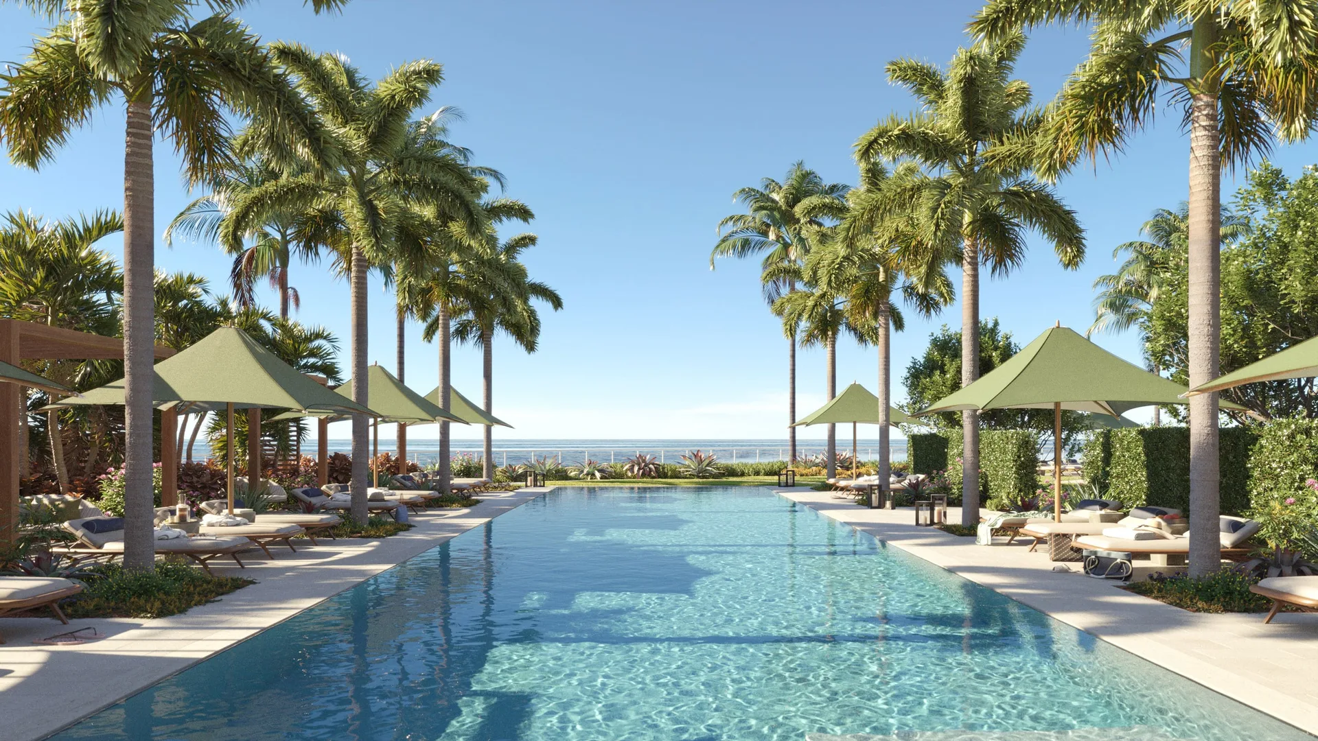 Piscina estilo resort en Rosewood Residences Naples bordeada de palmeras y tumbonas, con vista al mar