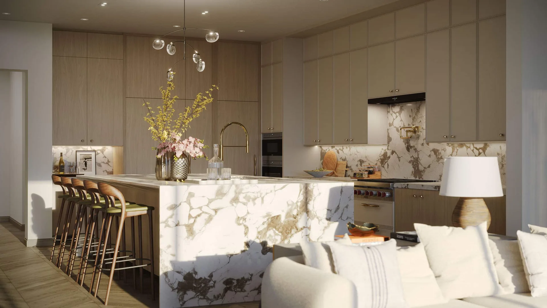 Cocina de la residencia en Rosewood Residences Naples con isla de marmol, veta dorada, gabinetes de roble claro y herrajes de bronce