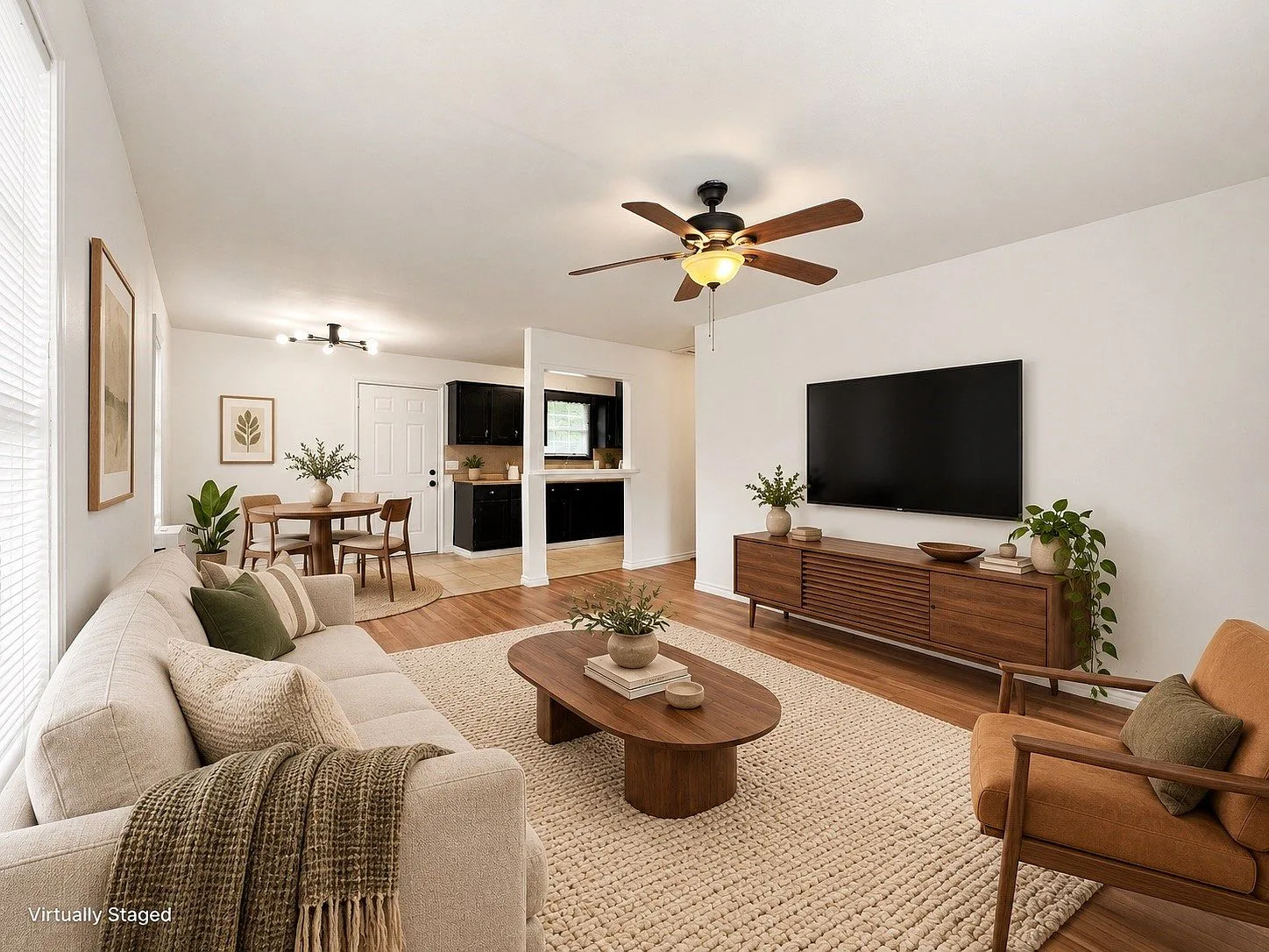 Open-concept living and dining room with wood floors and natural light