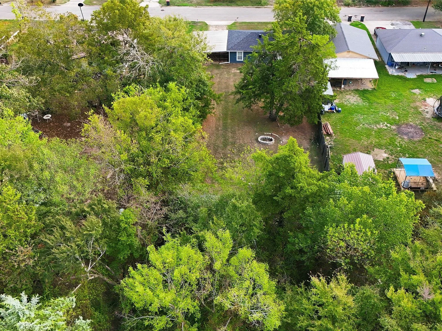 Aerial view of the backyard, carport, fire pit and storage shed