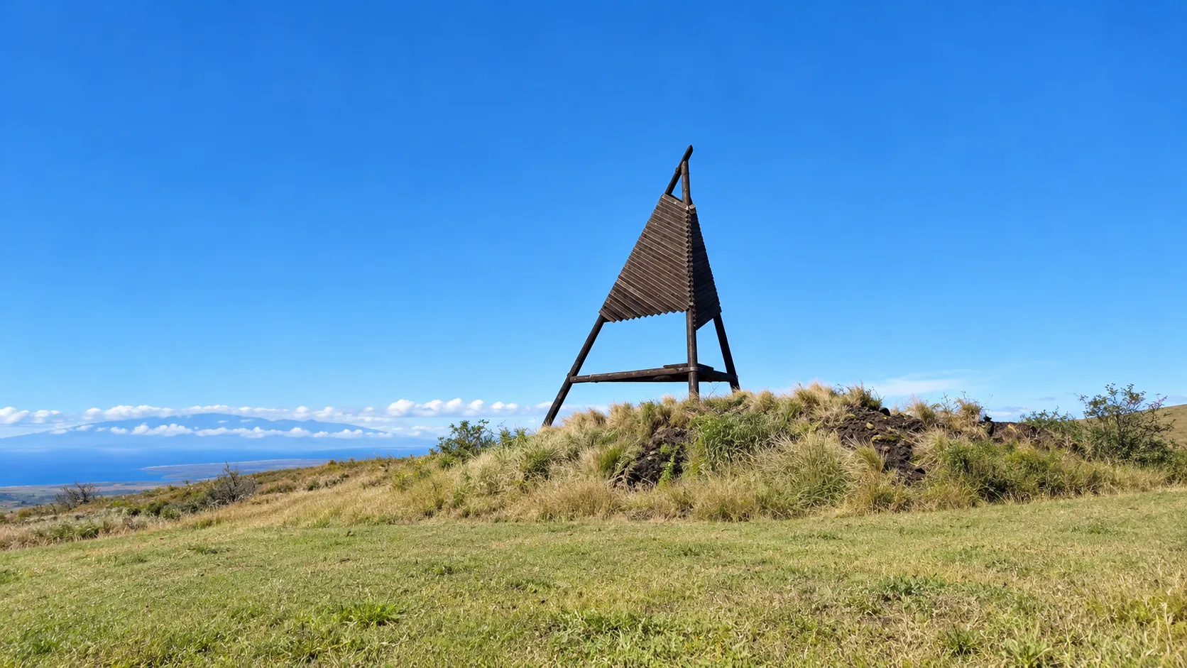 The sail-shaped Waikoloa Sail sculpture on the hilltop at the Waikoloa Road junction with Māmalahoa Highway