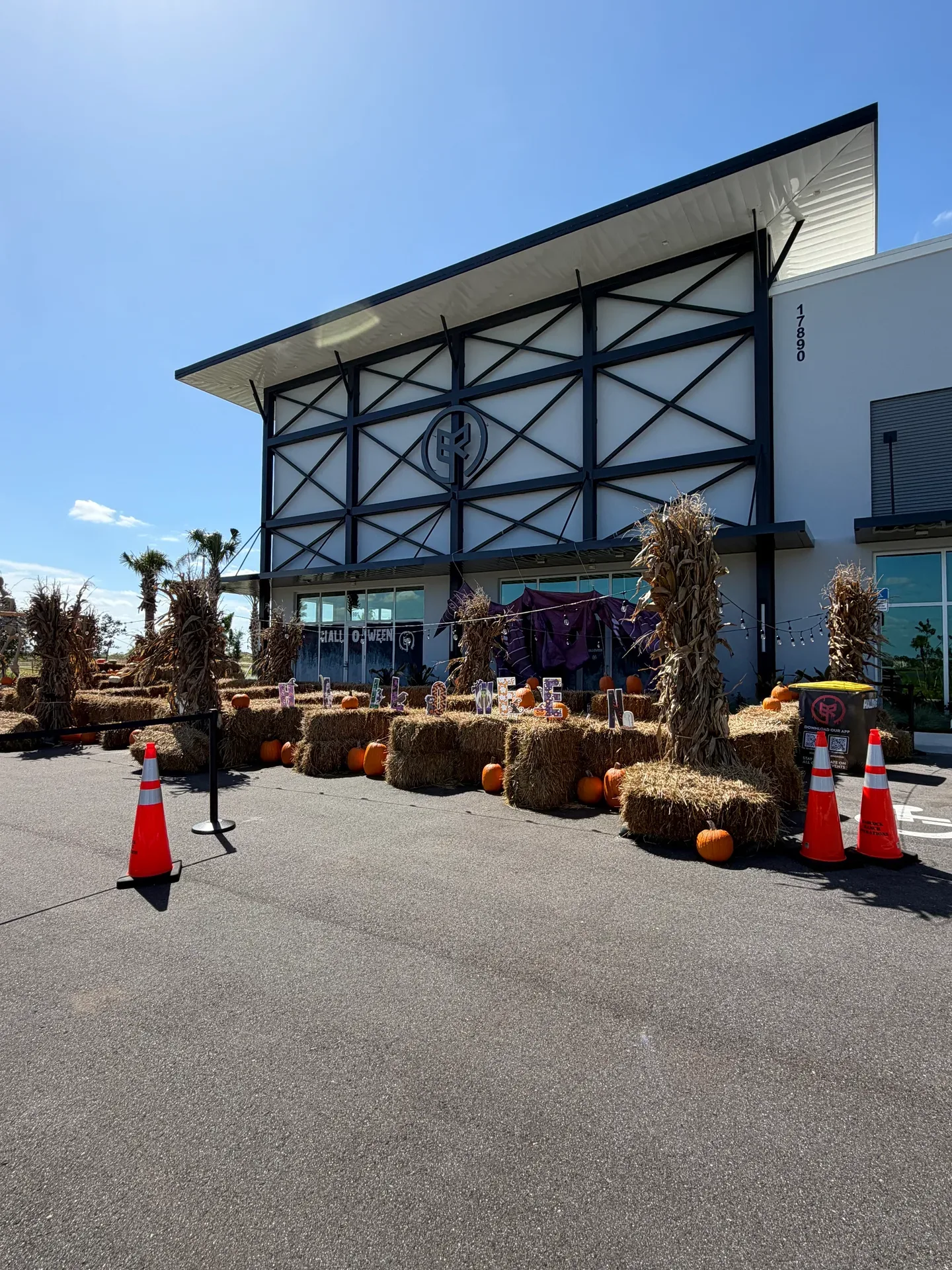 Curry Commerce Center storefront decorated for fall with HELLO FALL marquee lights and hay bales