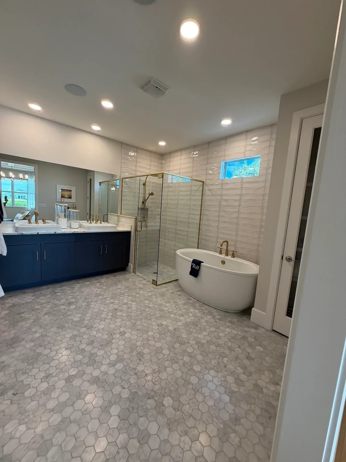Primary bathroom with a navy vanity and brass fixtures in a Regency at Babcock Ranch home