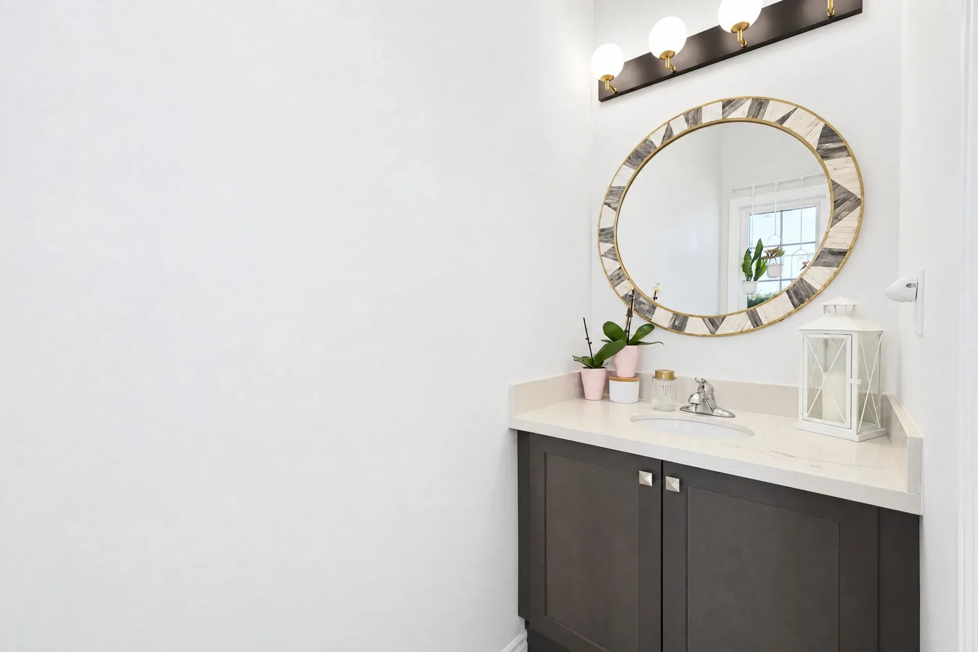 Bathroom vanity with dark cabinetry and a light stone countertop