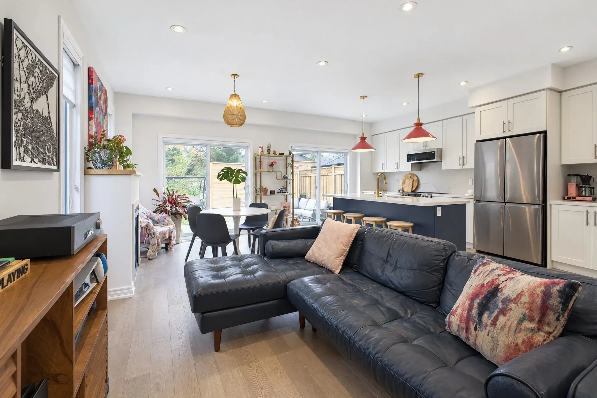 Open-concept living room and kitchen with light hardwood floors and a navy kitchen island