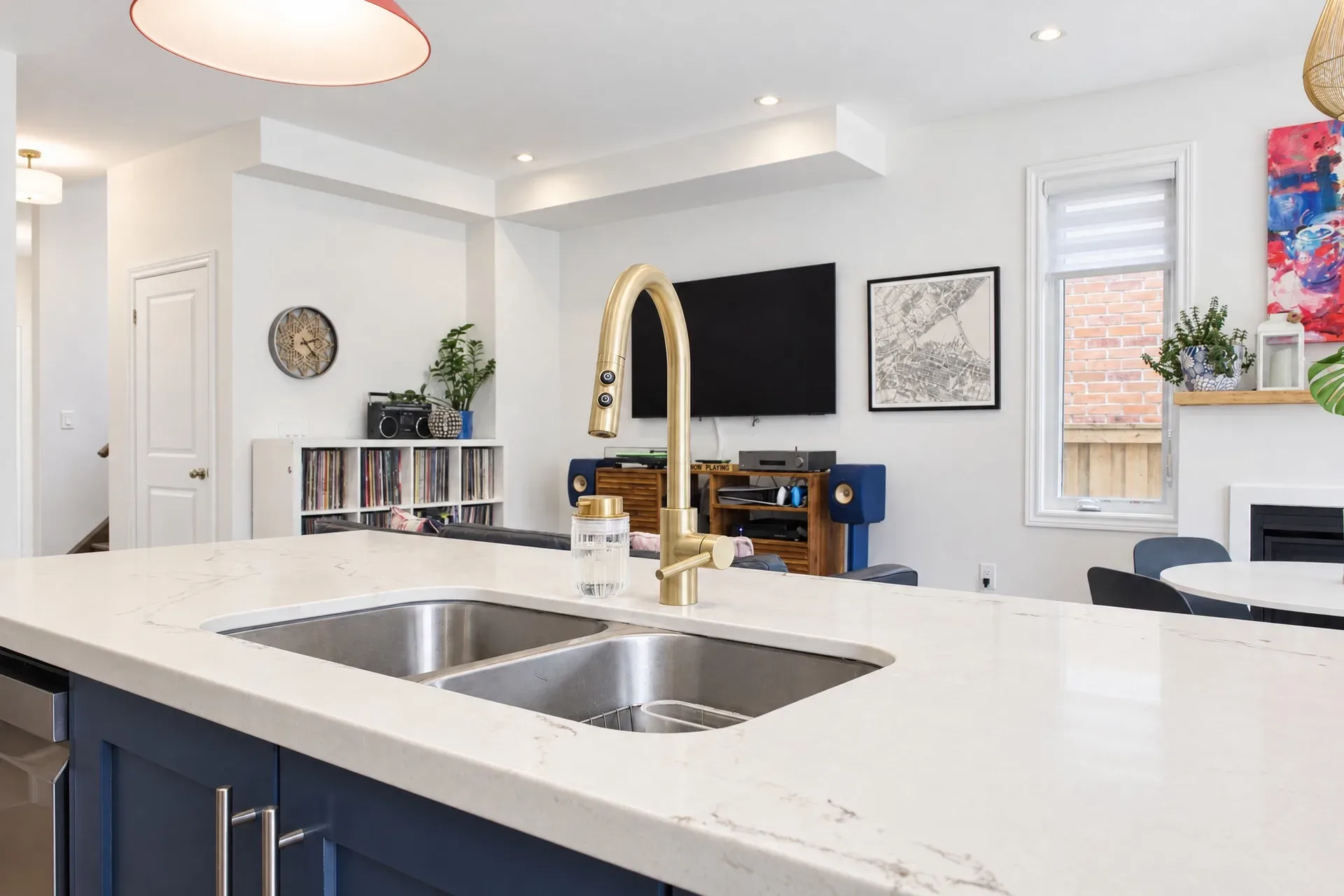 Kitchen to living view: Brass faucet and quartz island, sightlines through the home