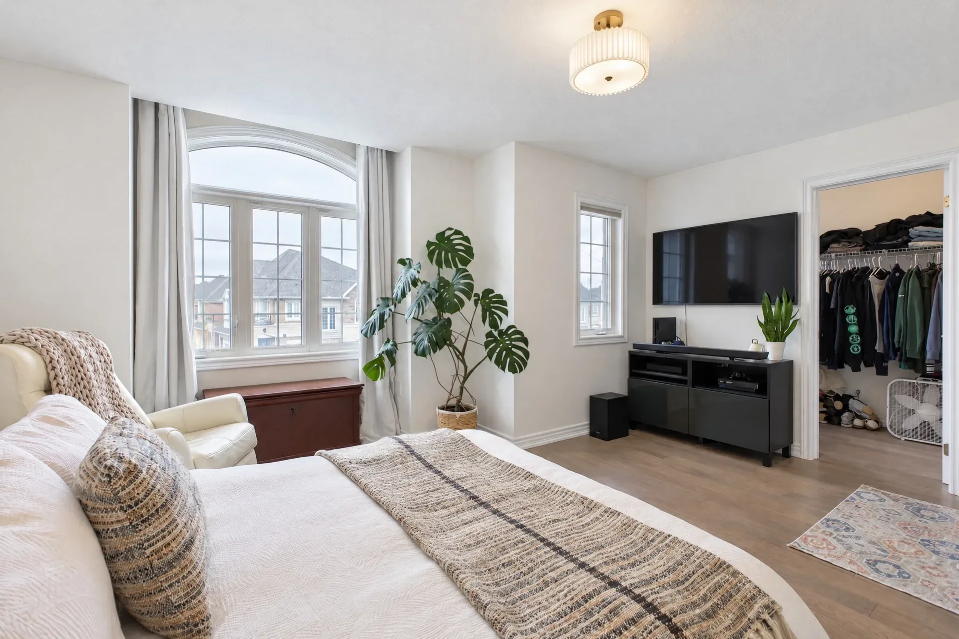Primary suite with an arched window letting in soft natural light