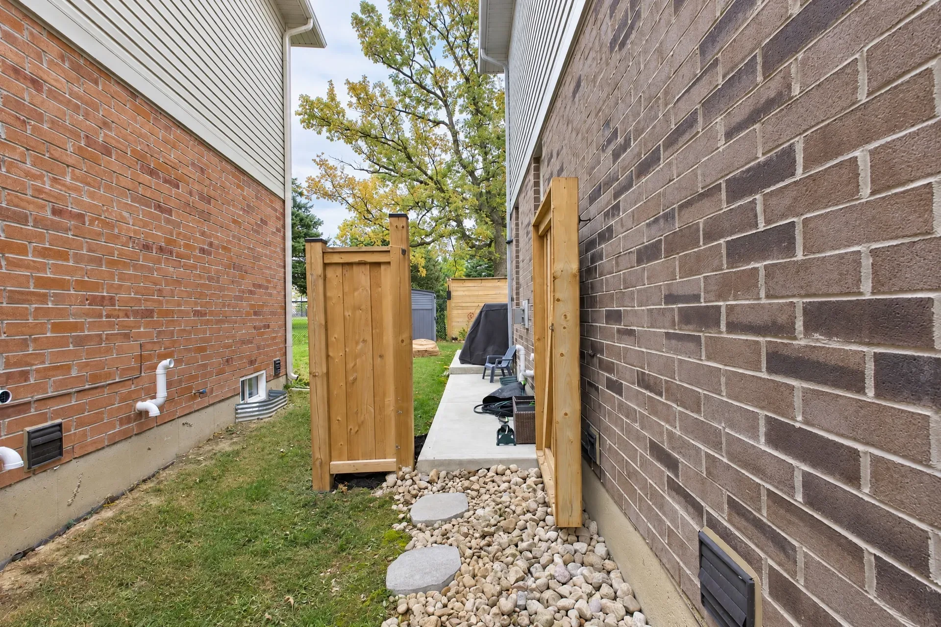 Side yard: Gated side access with gravel path