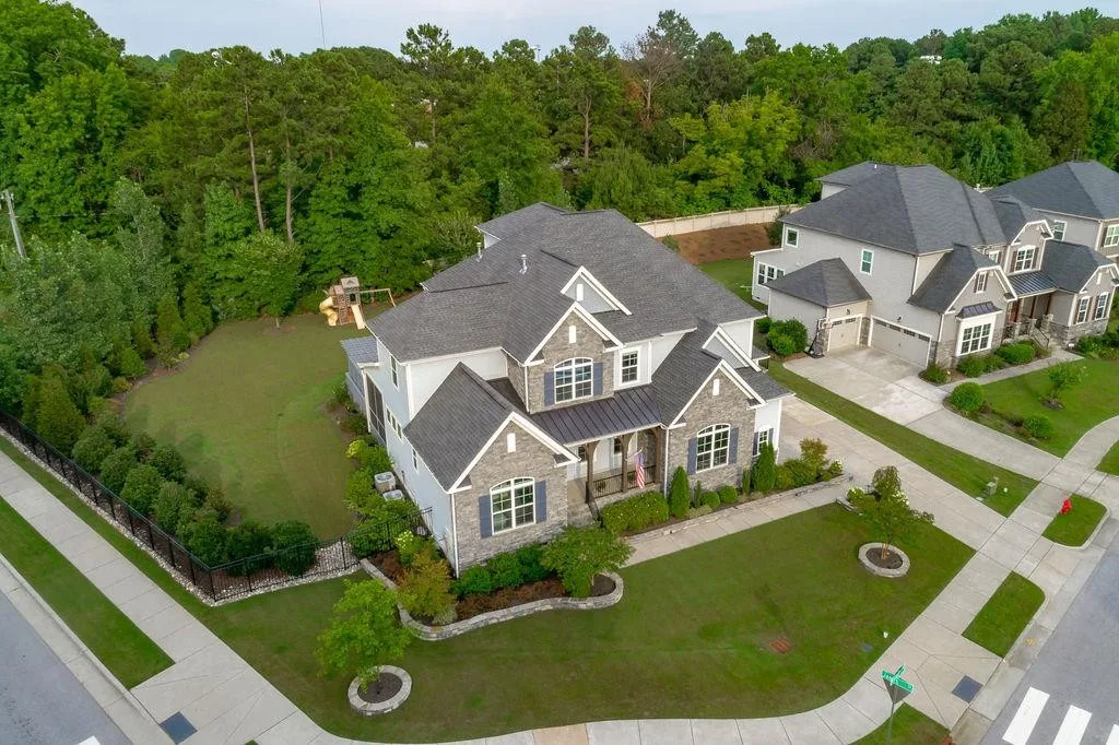 Aerial view of a corner-lot home with a sidewalk and kids' play set in Salem Village, Apex NC