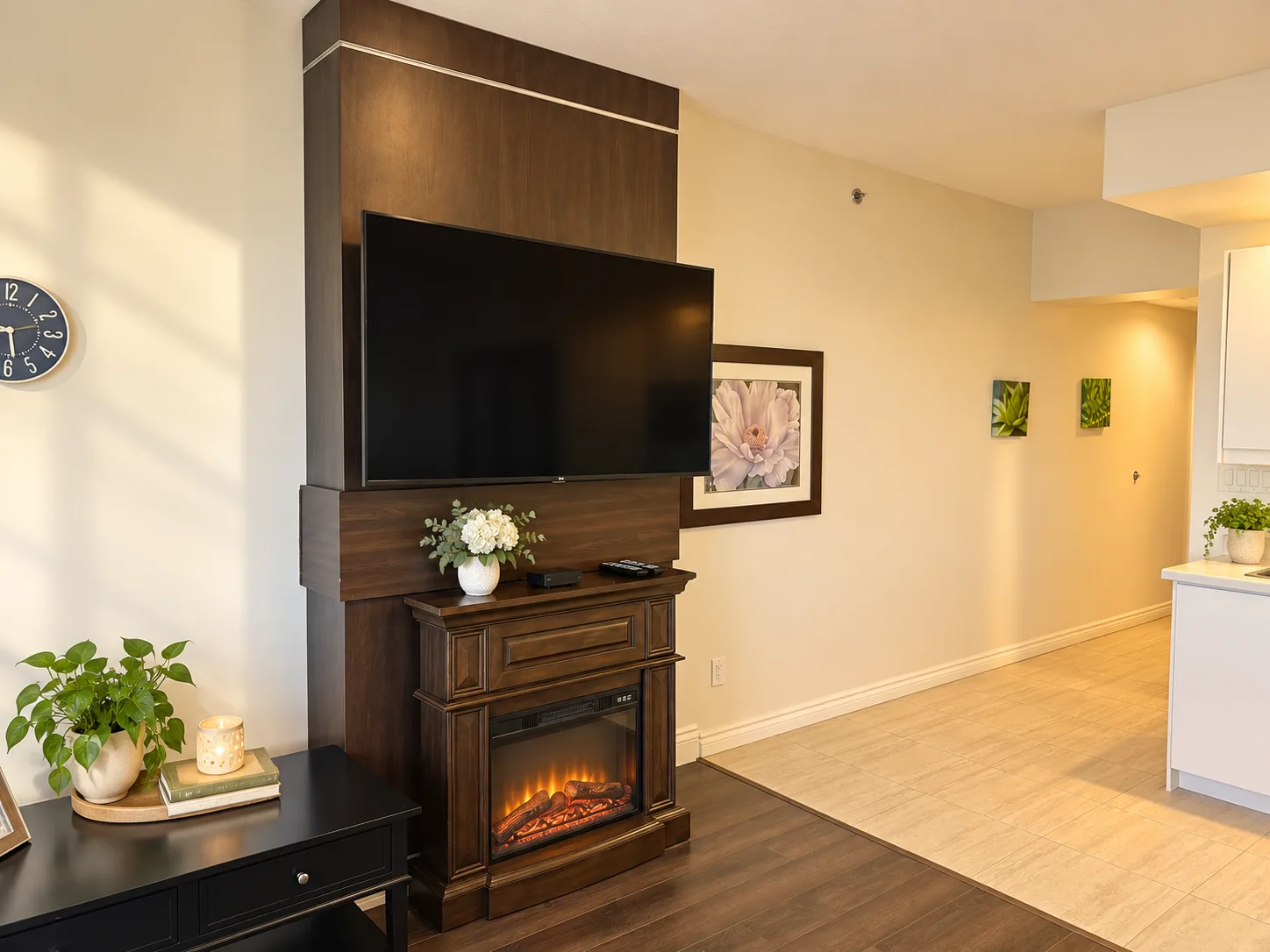 The Diamond Suite living room at Emerald Residence with an electric fireplace feature wall and a glimpse of the kitchenette