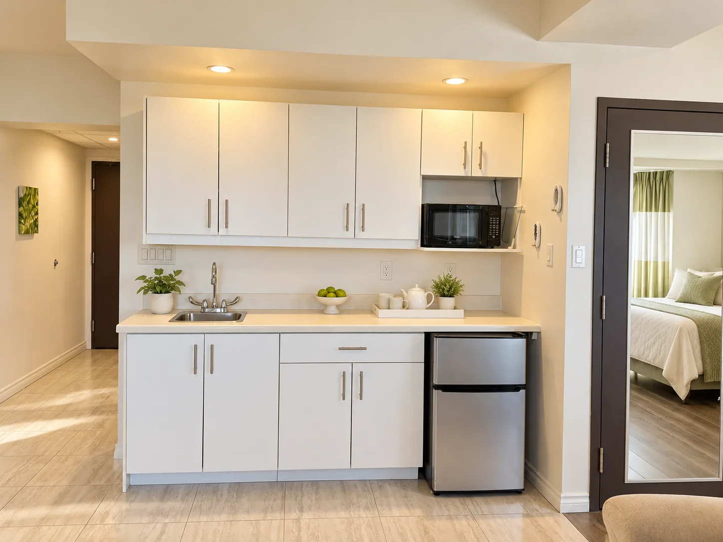 The Diamond Suite kitchenette and wet bar at Emerald Residence with white cabinetry and a mini-fridge