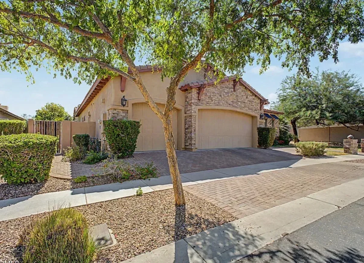 Street view of the villa showing the multi-car garage and landscaping