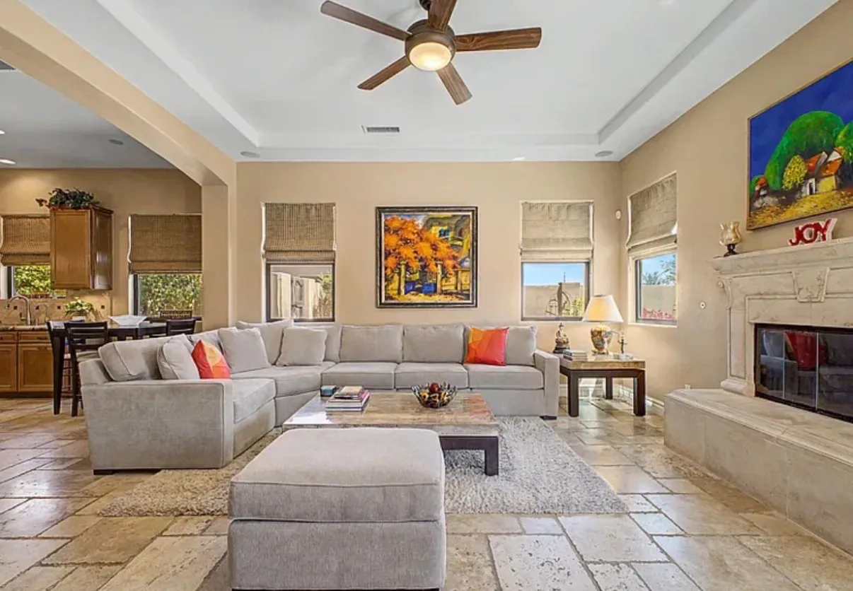 Wide living room view flowing into the kitchen with travertine flooring