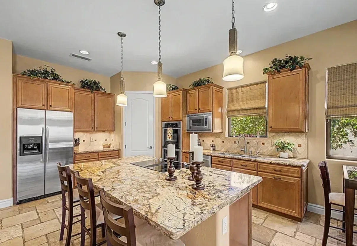 Kitchen with wood cabinetry, granite countertops, and a center island