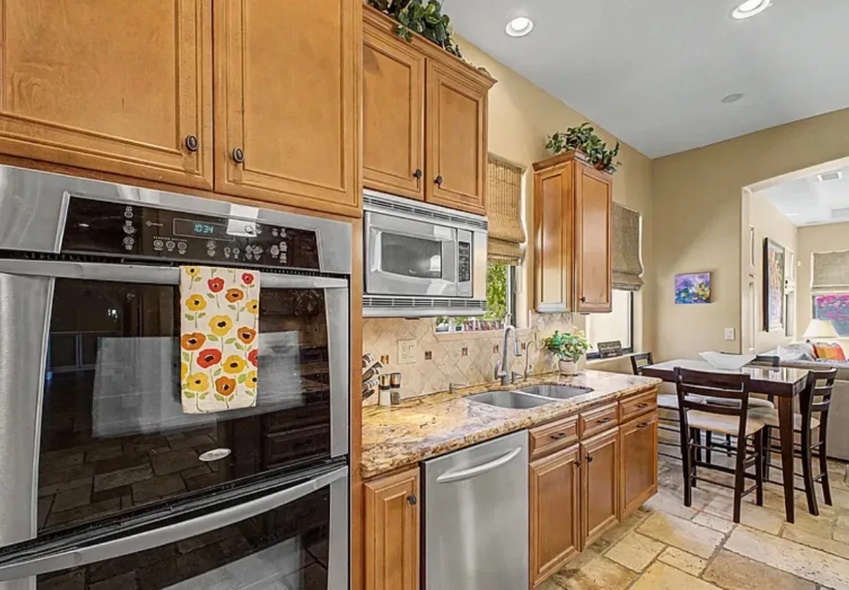 Kitchen and dining area with wood cabinetry and granite counters
