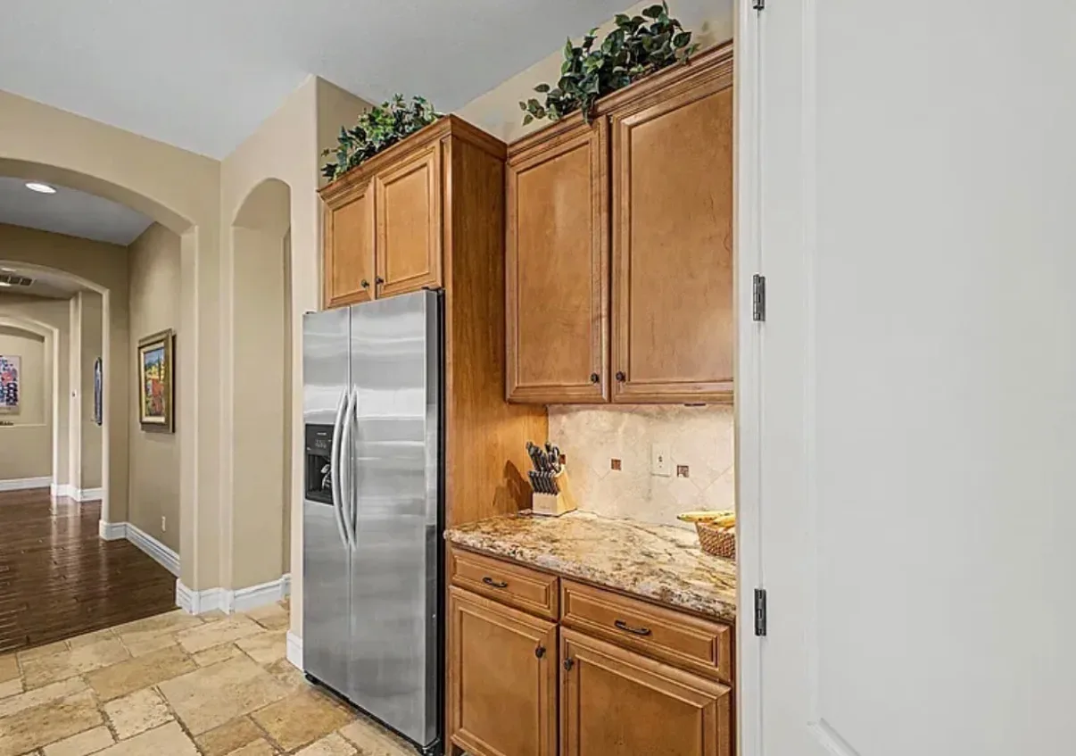 Kitchen nook near the refrigerator with honey-toned cabinetry