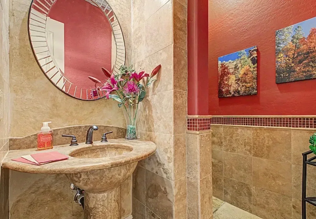 Guest bathroom with a travertine vanity and mosaic trim