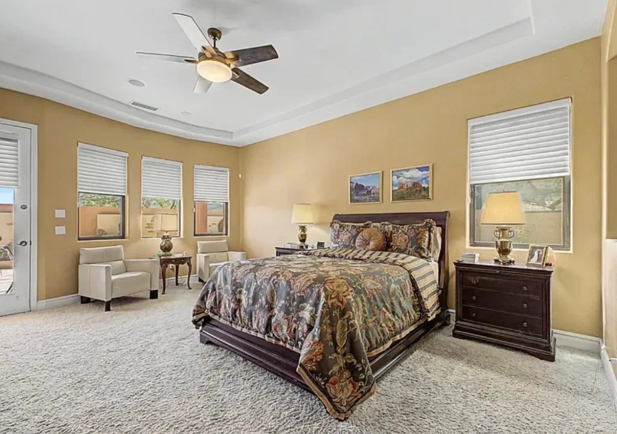 Wide view of the primary bedroom suite with recessed lighting