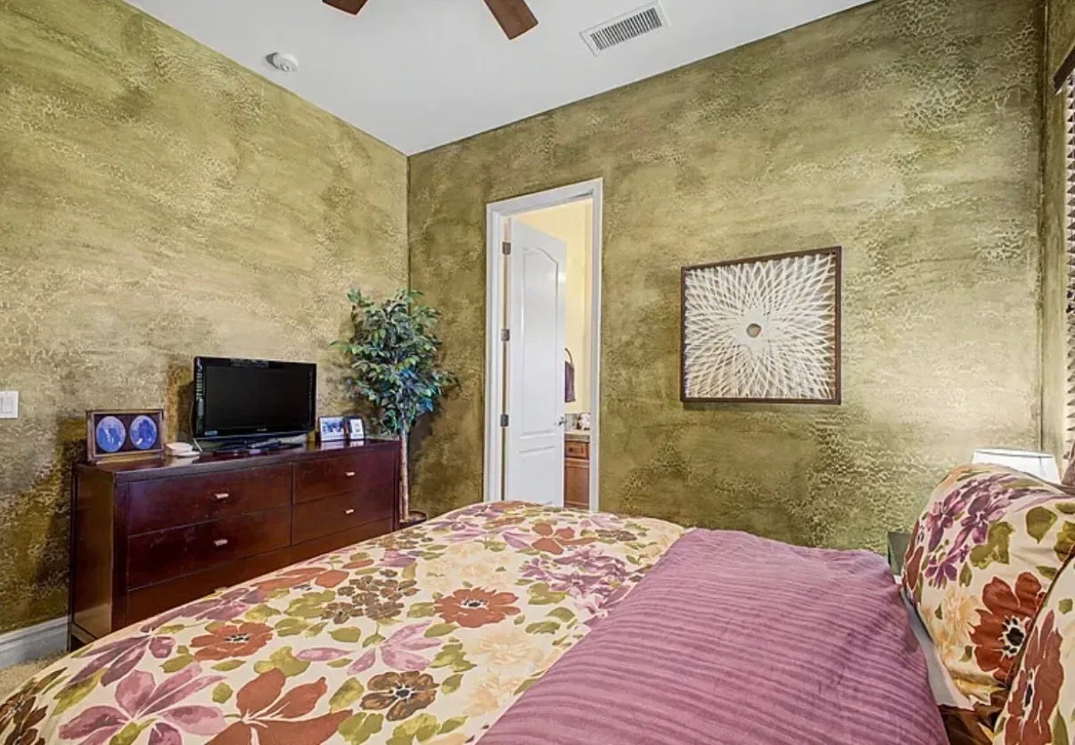 Guest bedroom with textured walls and a dressed bed