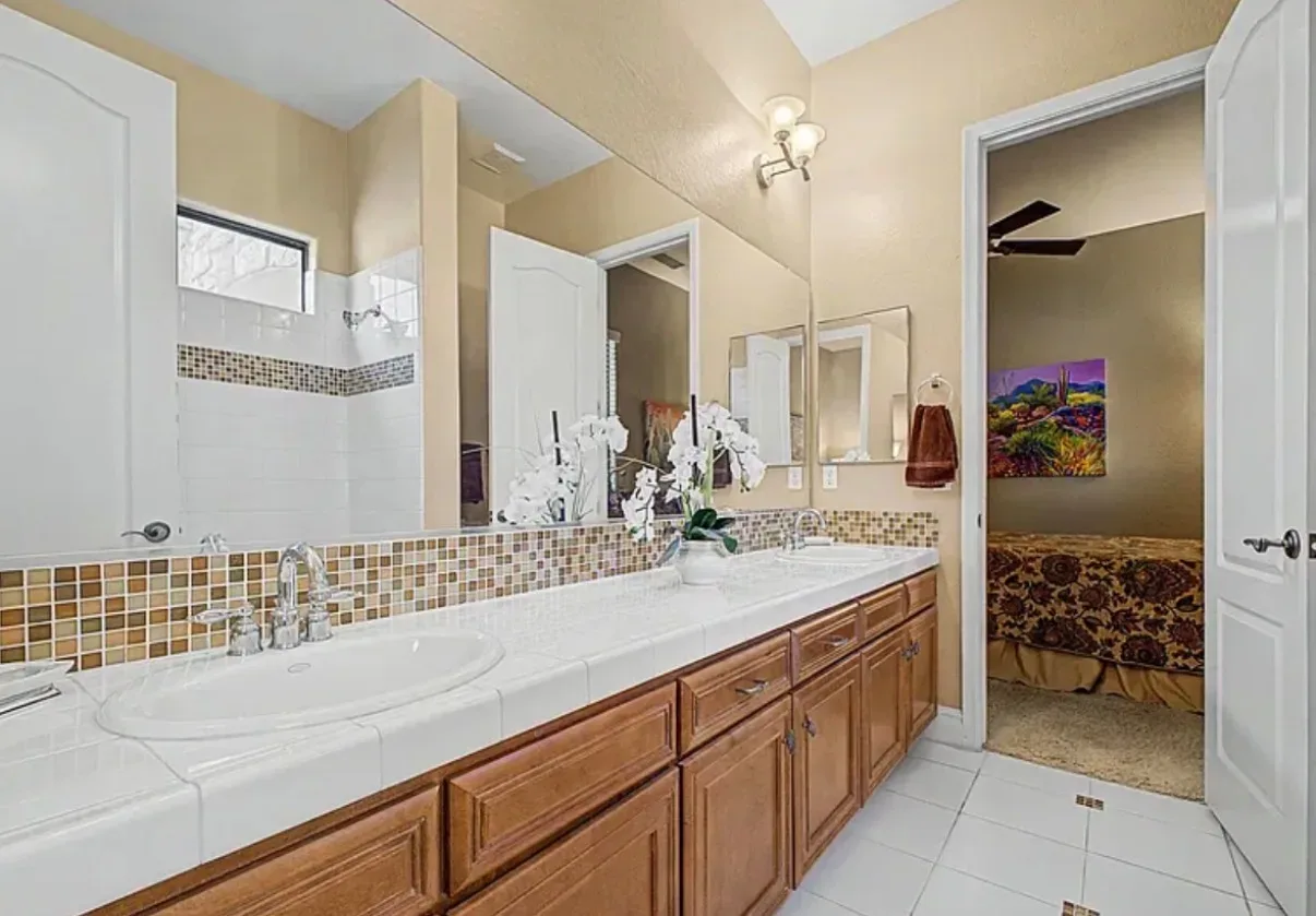 Bathroom with a double-sink vanity and mosaic backsplash
