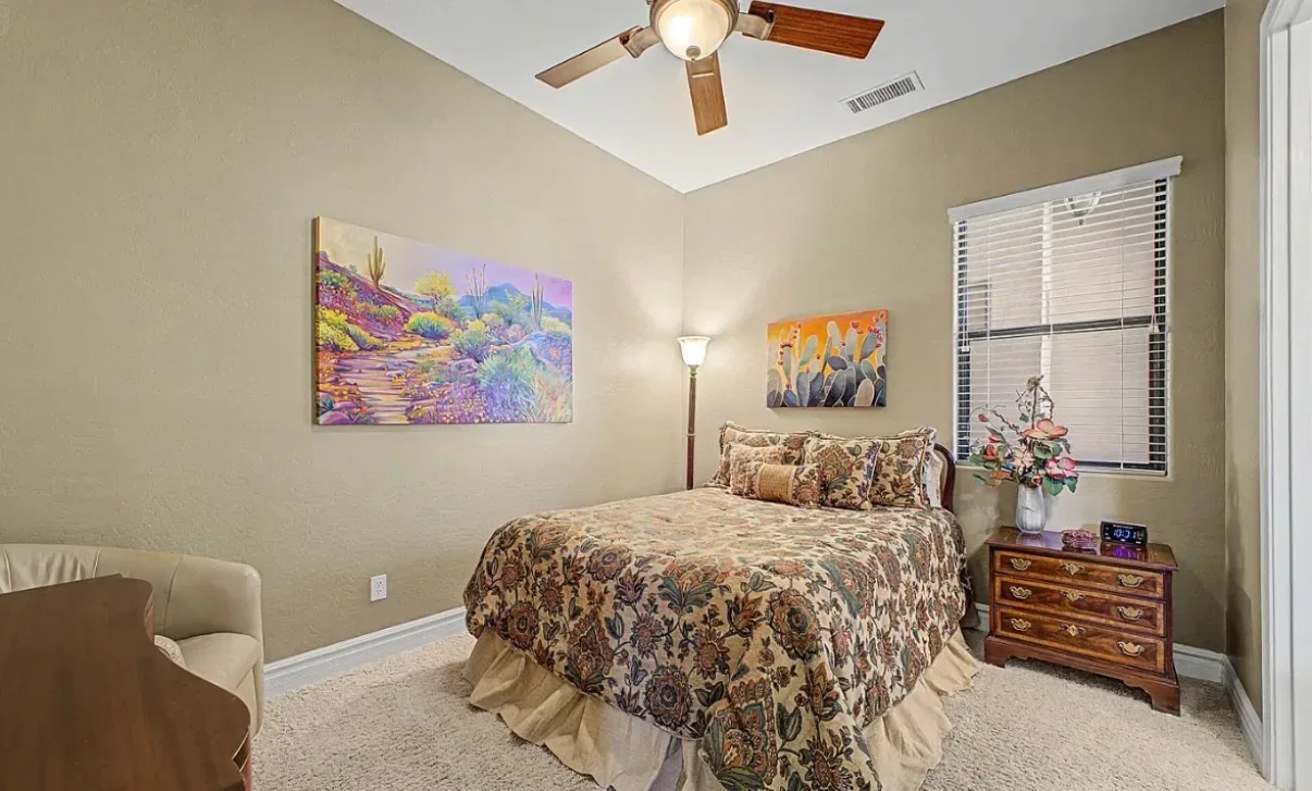 Secondary bedroom with a bed, nightstands, and an armchair