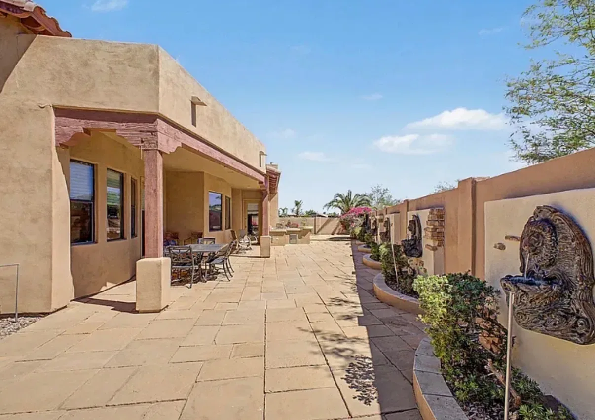 Side view of the backyard patio with travertine flooring and fountains