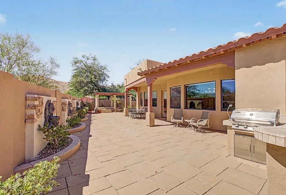 Backyard patio with a built-in grill and stone-paved outdoor space