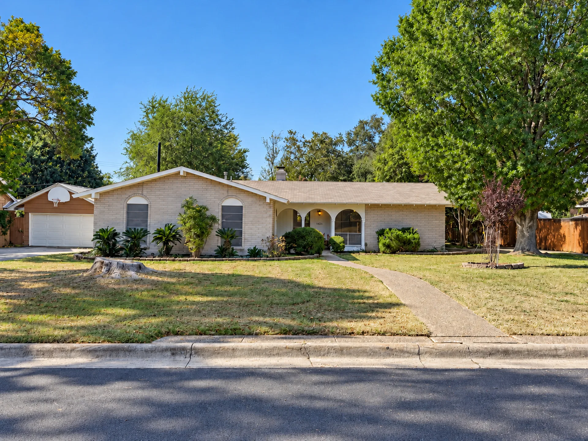 Front exterior of 14223 Clear Creek St, a single-story ranch home with light brick and an arched entryway
