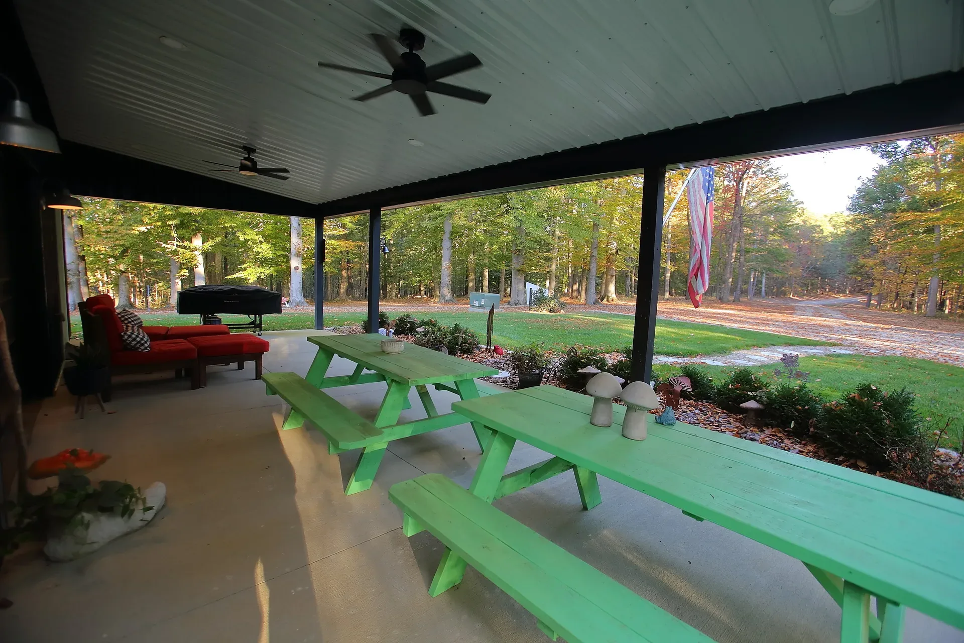 Wide covered porch with dark beams overlooking the woods