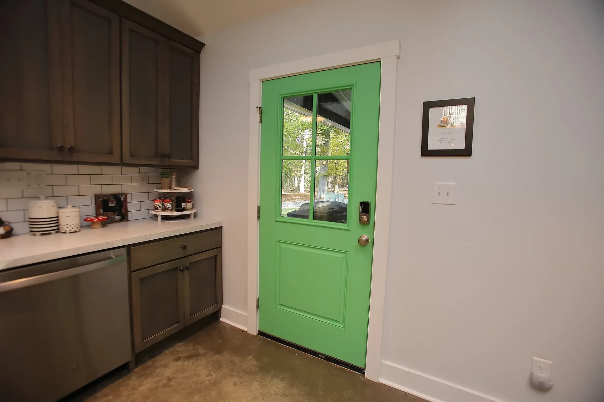 Kitchen with dark wood cabinets and a bright green exterior door