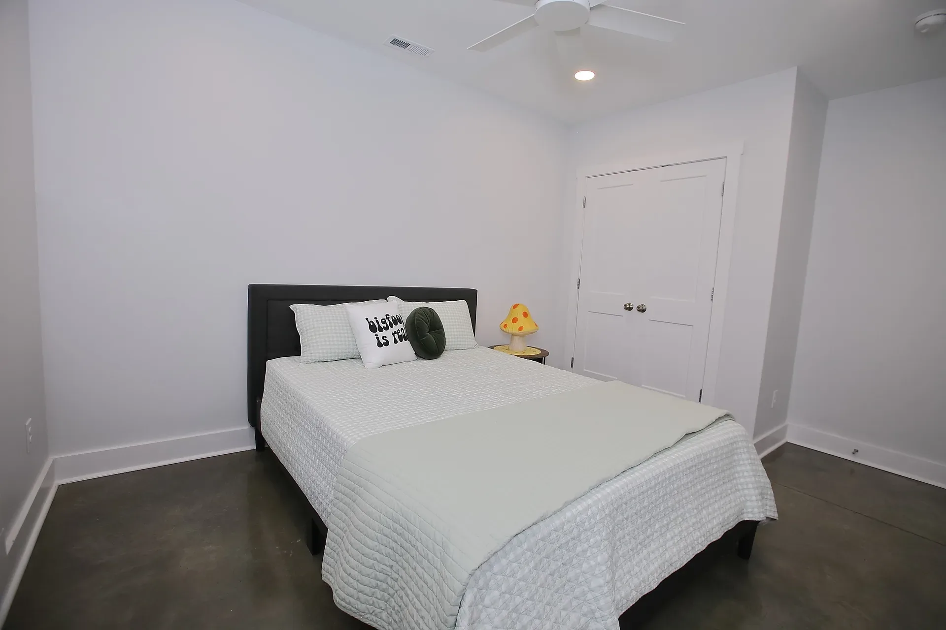Bedroom with white walls and polished concrete floor