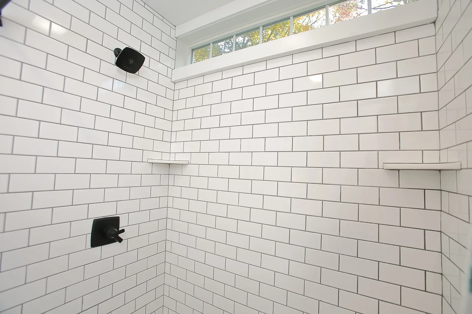 Walk-in shower with subway tile and matte black fixtures