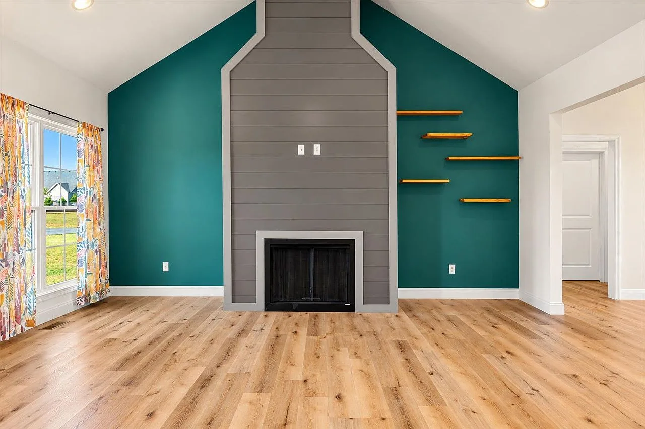 Great room fireplace wall beneath a vaulted ceiling