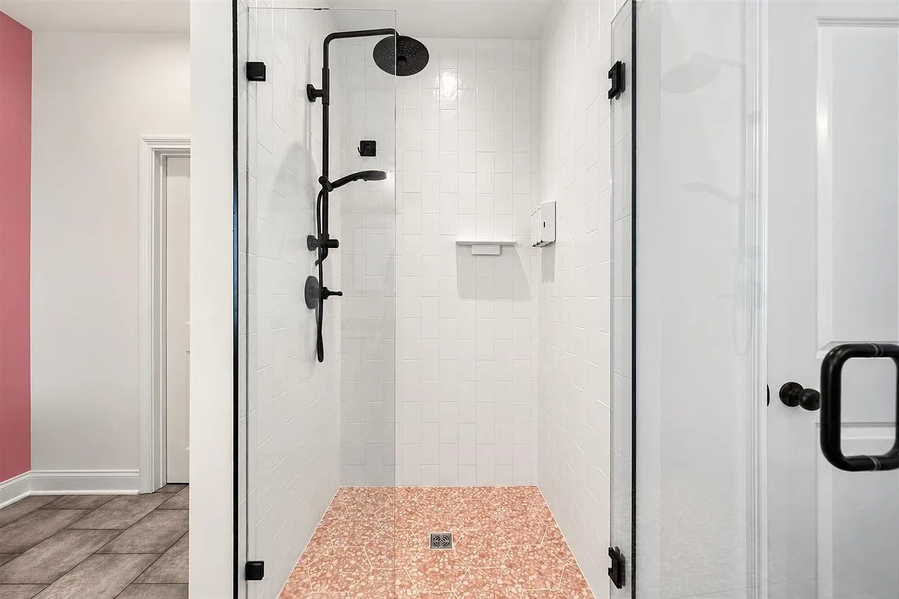 Primary bathroom walk-in shower with white subway tile and a matte black rain shower head