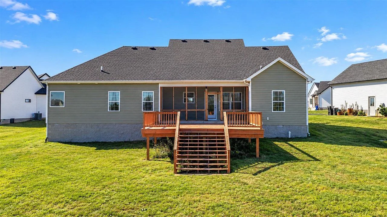Rear elevation of the home with the raised wooden deck and screened porch